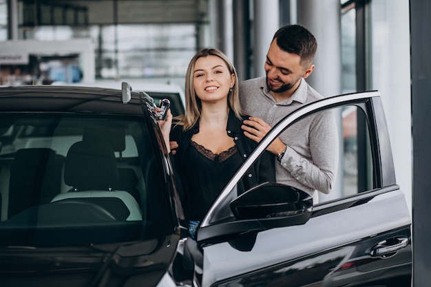 Jeune couple, choisir, a, voiture, dans, a, exposition voiture, salle