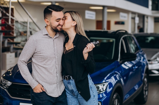 Jeune couple, choisir, a, voiture, dans, a, exposition voiture, salle