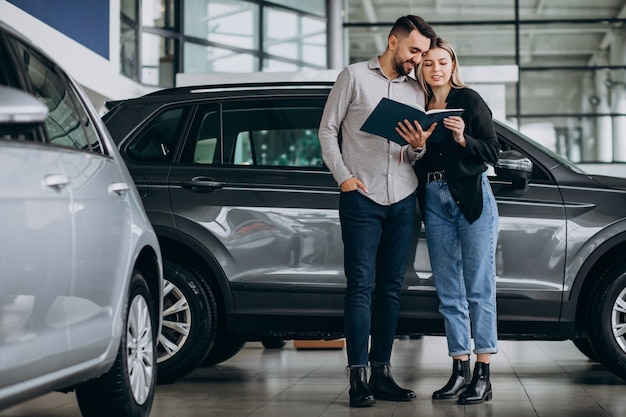 Jeune couple, choisir, a, voiture, dans, a, exposition voiture, salle