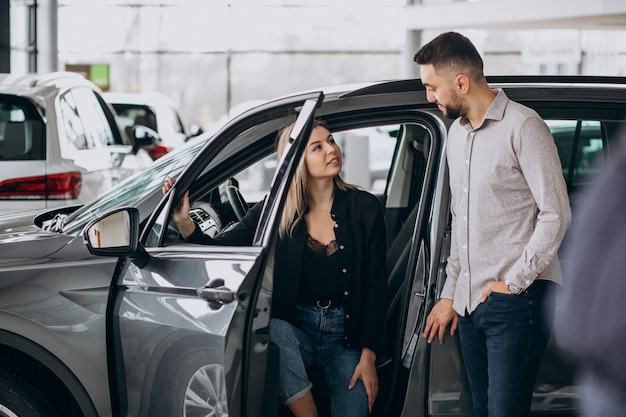 Jeune couple, choisir, a, voiture, dans, a, exposition voiture, salle