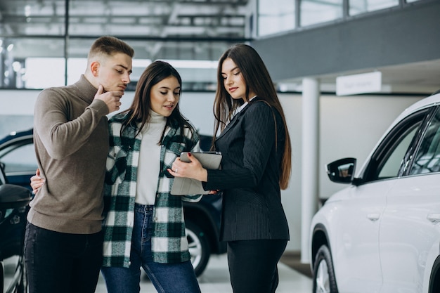 Jeune couple, choisir, a, voiture, dans, a, exposition voiture, salle