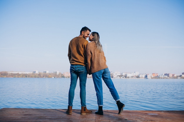 Jeune couple dans un parc debout près de la rivière