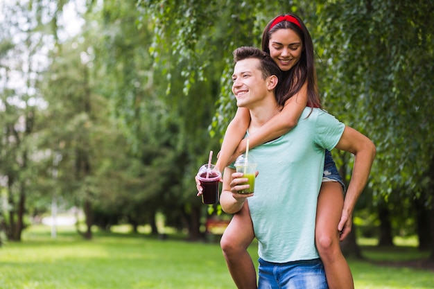 Jeune couple dans le parc, profiter de smoothies sains