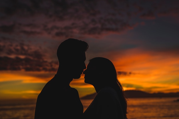 Jeune couple, debout, bord mer, nuit