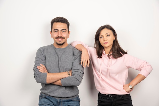 Jeune couple debout avec une expression heureuse.