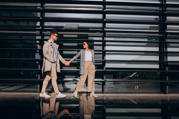 Jeune couple debout près du bâtiment