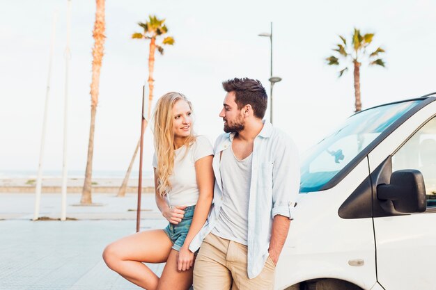 Jeune couple debout près de la voiture