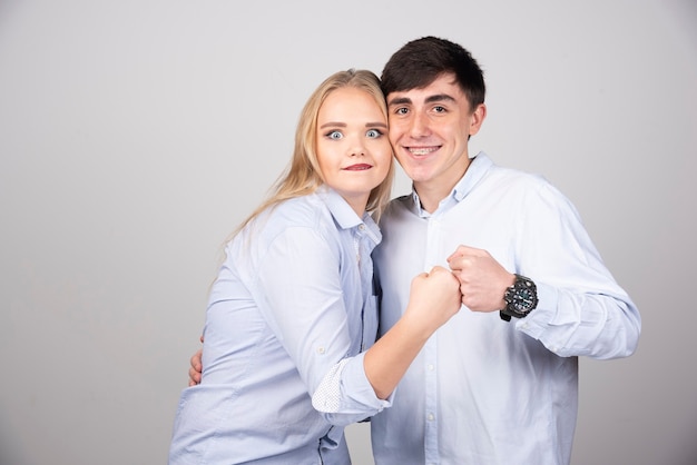 Jeune couple debout et regardant la caméra en souriant