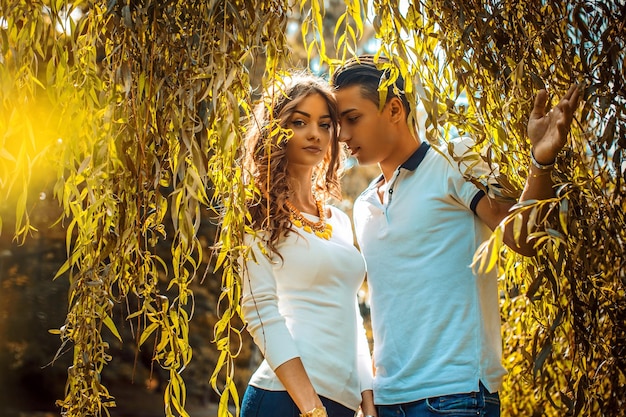 Un jeune couple décontracté s'amuse sous un arbre vert.