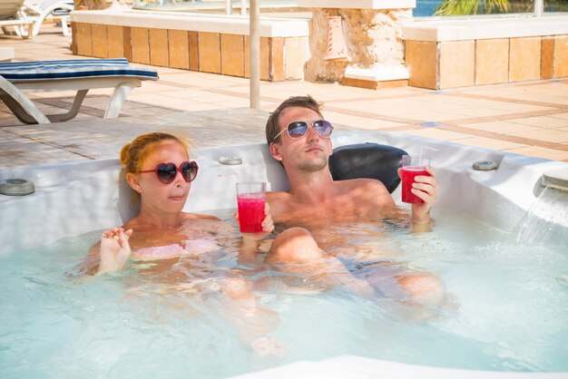 Jeune couple de détente dans la piscine jacuzzi