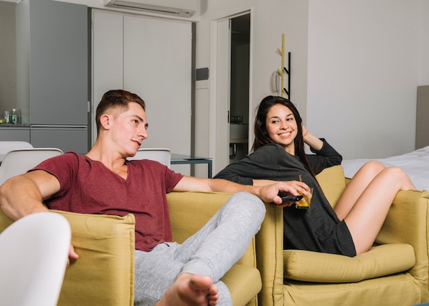 Jeune couple devant la télé à la maison