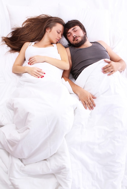 Jeune couple dort dans son lit