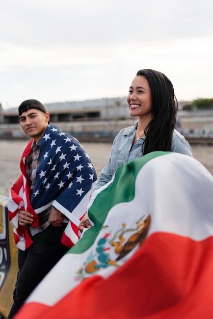 Jeune couple avec des drapeaux à côté de la rivière