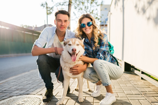 Jeune couple élégant posant avec un chien dans la rue