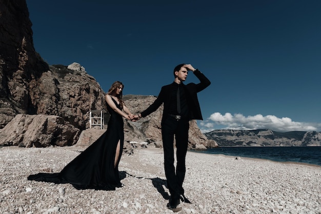 Jeune couple élégant près de la mer et des rochers