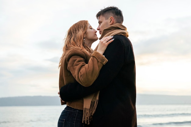 Jeune couple embrassant sur la plage en hiver