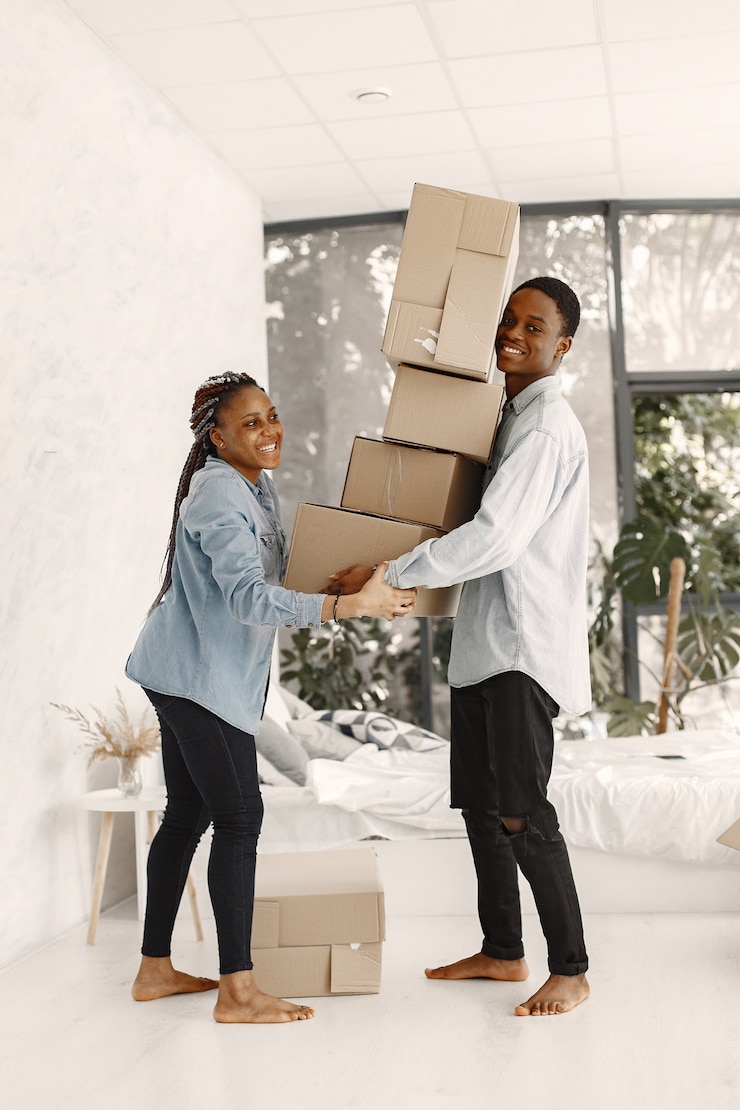 Photo gratuit jeune couple emménageant dans une nouvelle maison ensemble. couple afro-américain avec des boîtes en carton.
