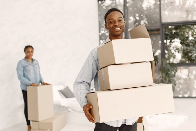 Jeune couple emménageant dans une nouvelle maison ensemble. Couple afro-américain avec des boîtes en carton.