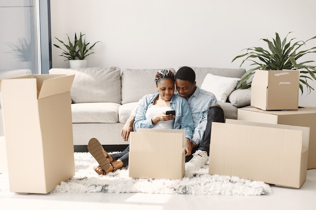 Jeune couple emménageant dans une nouvelle maison ensemble. Couple afro-américain avec des boîtes en carton.