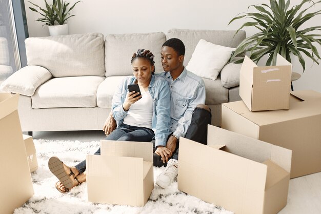 Jeune couple emménageant dans une nouvelle maison ensemble. Couple afro-américain avec des boîtes en carton.