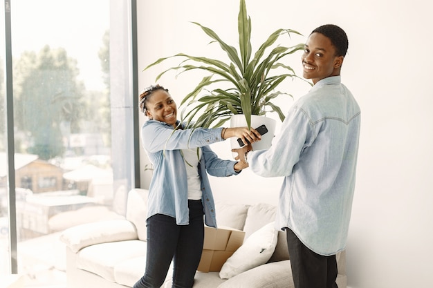 Jeune couple emménageant dans une nouvelle maison ensemble. Couple afro-américain avec des boîtes en carton.