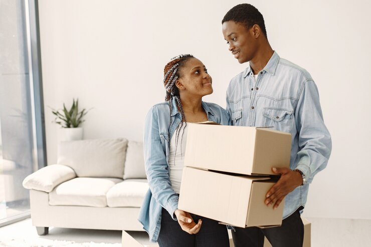 Photo gratuit jeune couple emménageant dans une nouvelle maison ensemble. couple afro-américain avec des boîtes en carton.