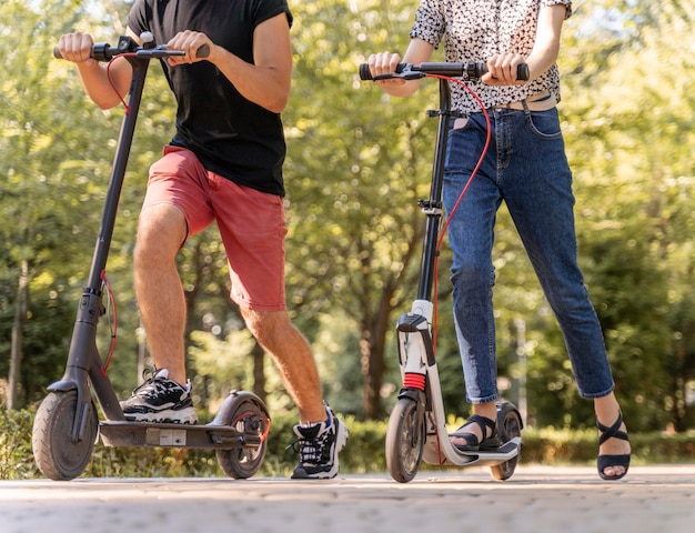 Jeune couple, équitation, scooters, dehors