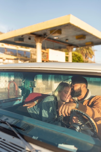 Jeune couple étreignant dans la voiture avant leur voyage