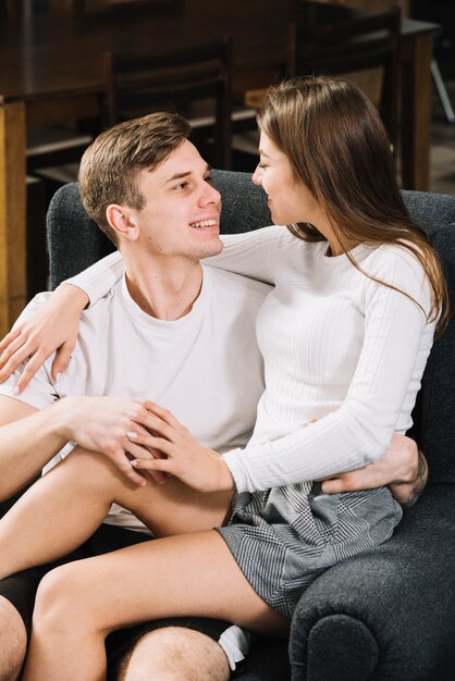 Jeune couple, étreindre, dans fauteuil