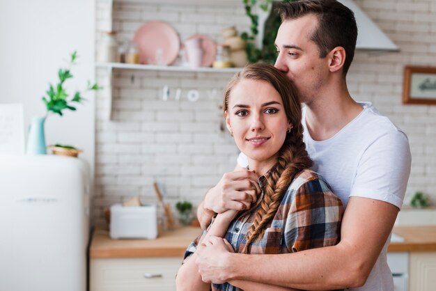 Jeune couple, étreindre, s&#39;embrasser, cuisine