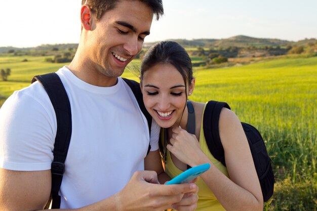 Jeune couple à l&#39;extérieur en regardant le téléphone portable