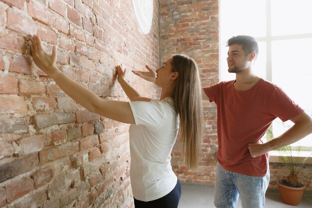 Jeune couple faisant la réparation d'appartement ensemble eux-mêmes. Homme marié et femme faisant la rénovation ou la rénovation de la maison