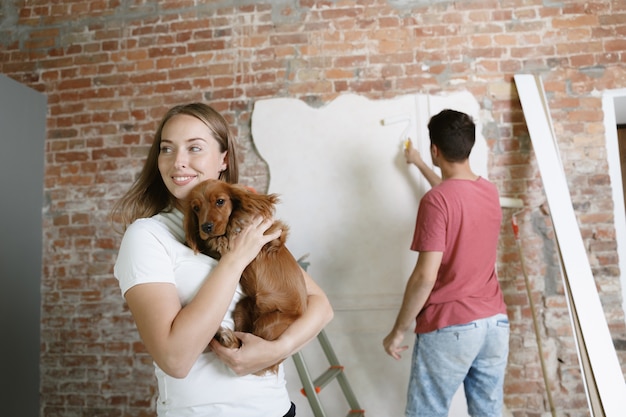 Jeune couple faisant la réparation d'appartement ensemble eux-mêmes. Homme marié et femme faisant la rénovation ou la rénovation de la maison