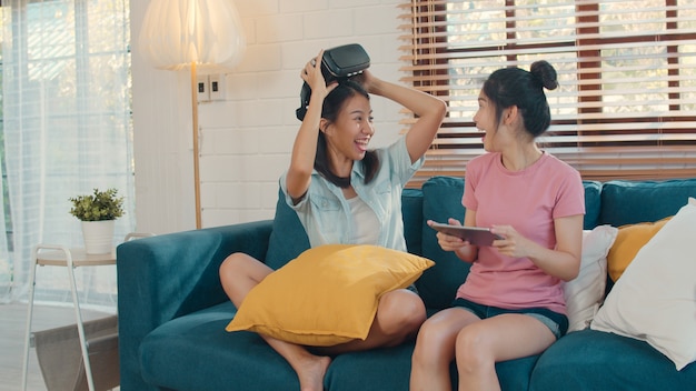 Jeune couple de femmes asiatiques lgbtq lgbtq utilisant une tablette à la maison