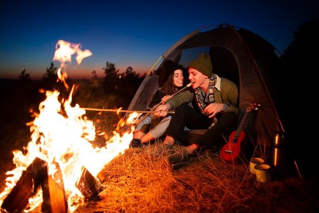 Jeune couple avec un feu de joie