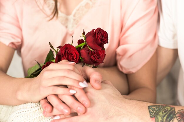 Jeune couple, à, fleurs, tenant mains