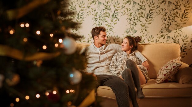 Jeune couple heureux assis sur un canapé