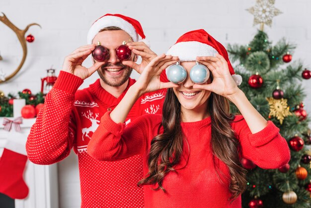 Jeune couple heureux avec des boules décoratives