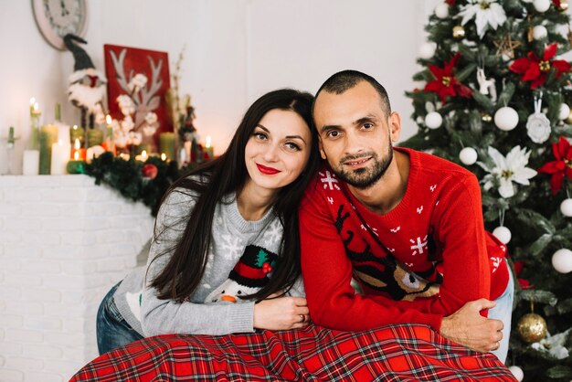 Jeune couple heureux près de sapin de Noël