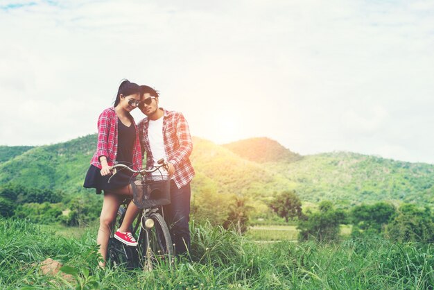 Jeune couple hippie tenant la main marchant sur la prairie relaxine