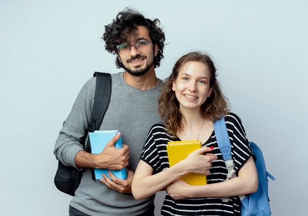 Jeune couple, homme femme, tenue, livres, regarder appareil-photo, sourire heureux, et, positif, debout, sur, fond blanc