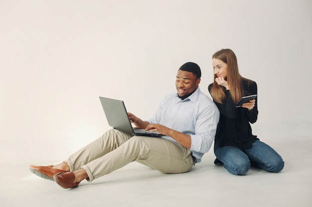 Jeune couple international travaillant ensemble et utilisant l'ordinateur portable