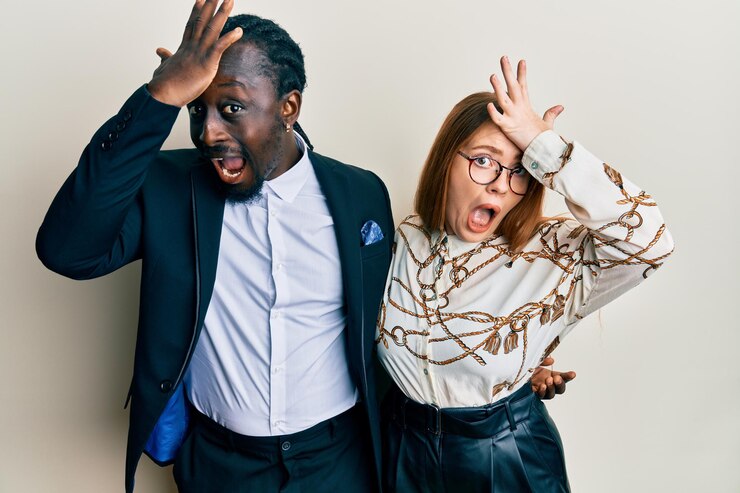Photo gratuit jeune couple interracial portant des vêtements d'affaires et élégants surpris avec la main sur la tête pour erreur, rappelez-vous l'erreur. oublié, mauvaise notion de mémoire.