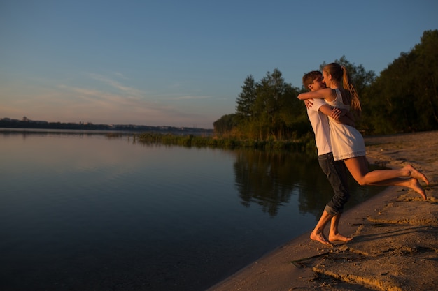 Jeune couple jouant sur la rive