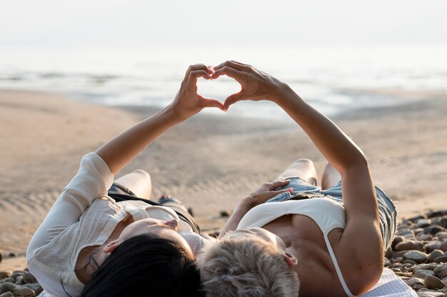 Jeune couple de lesbiennes en forme de coeur main