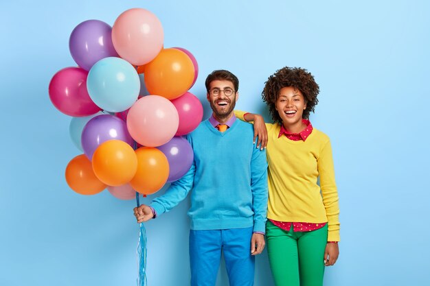 jeune couple lors d'une fête posant avec des ballons