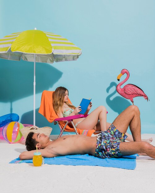 Jeune couple en maillot de bain relaxant sur la plage
