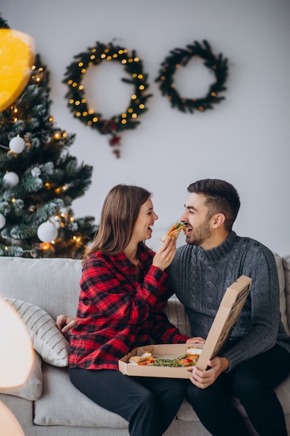 Jeune couple, manger, pizza, chez soi, noël