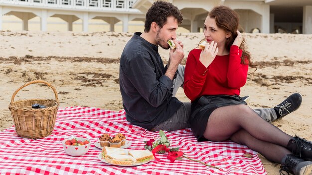 Jeune couple, manger, sandwichs, sur, couvre-lit