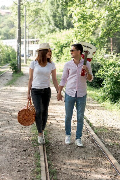 Jeune couple marchant sur une voie ferrée